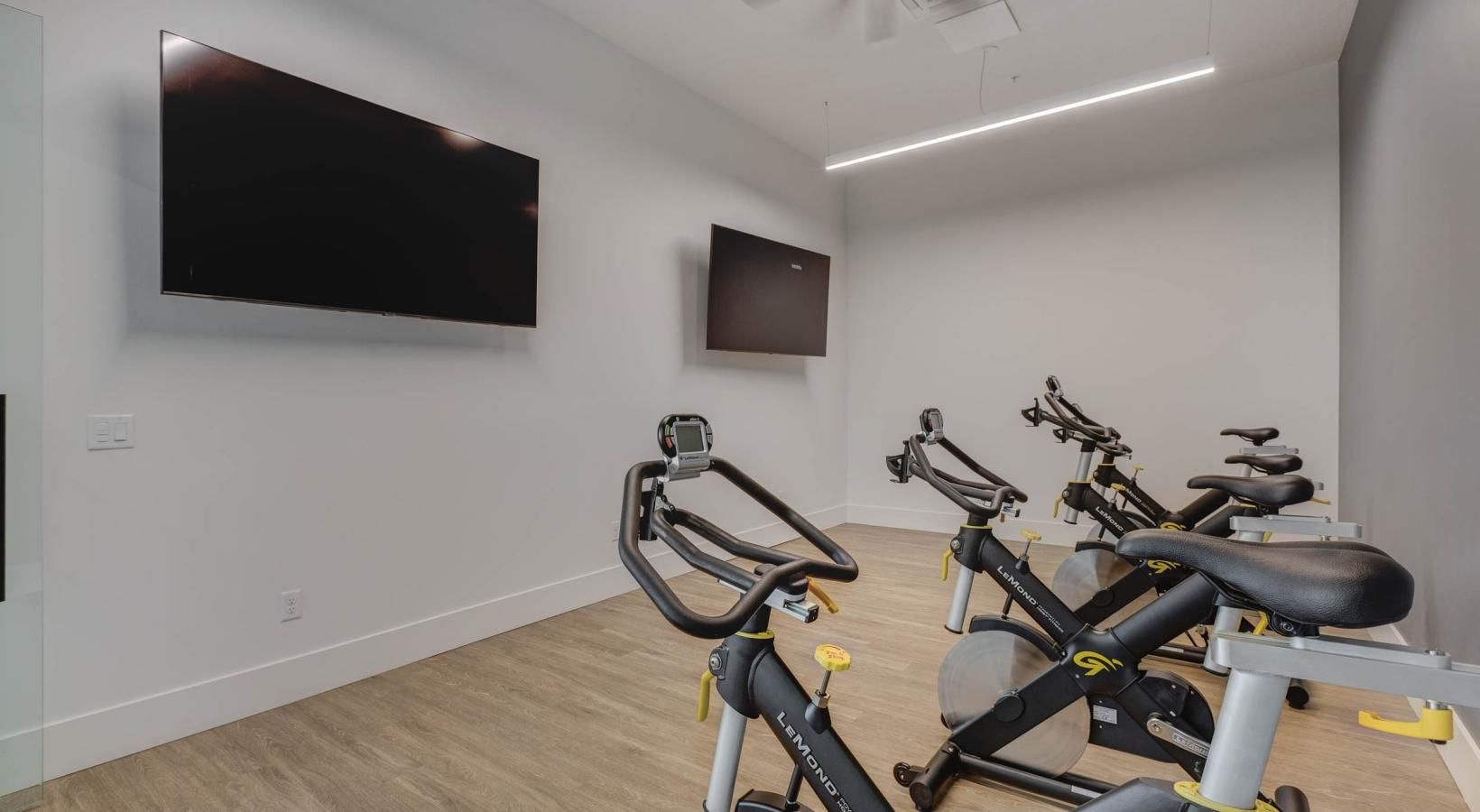 a room with exercise equipment and a tv on the wall